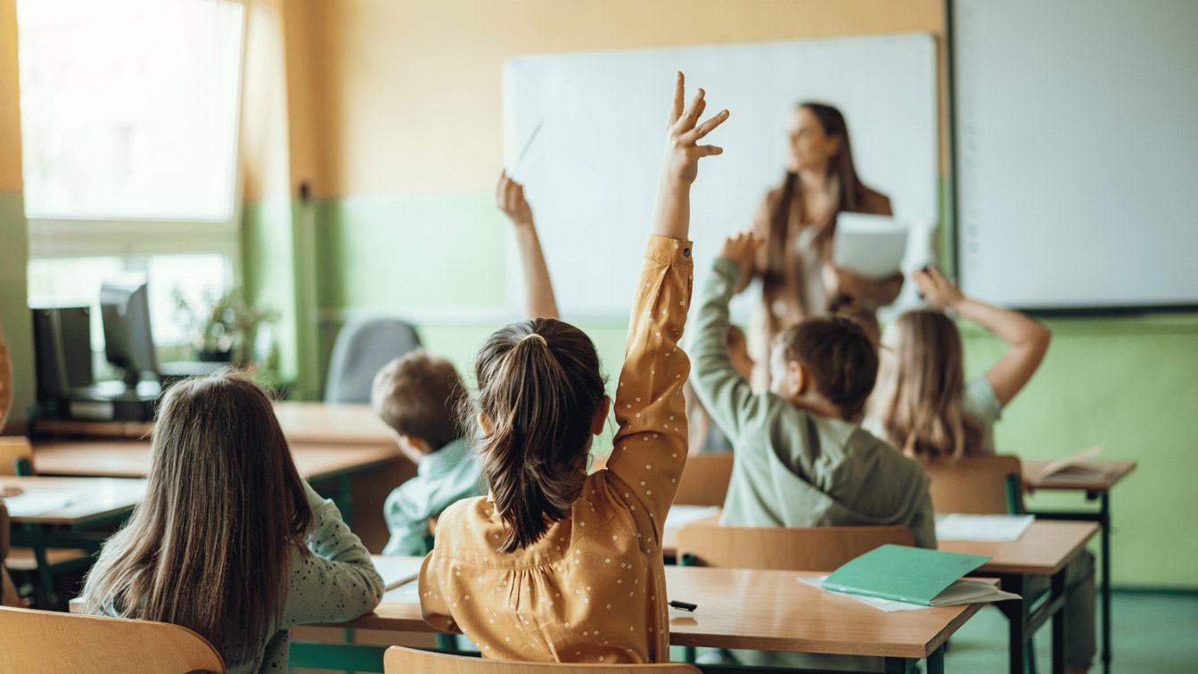 Lehrerin stellt im Klassenzimmer fragen