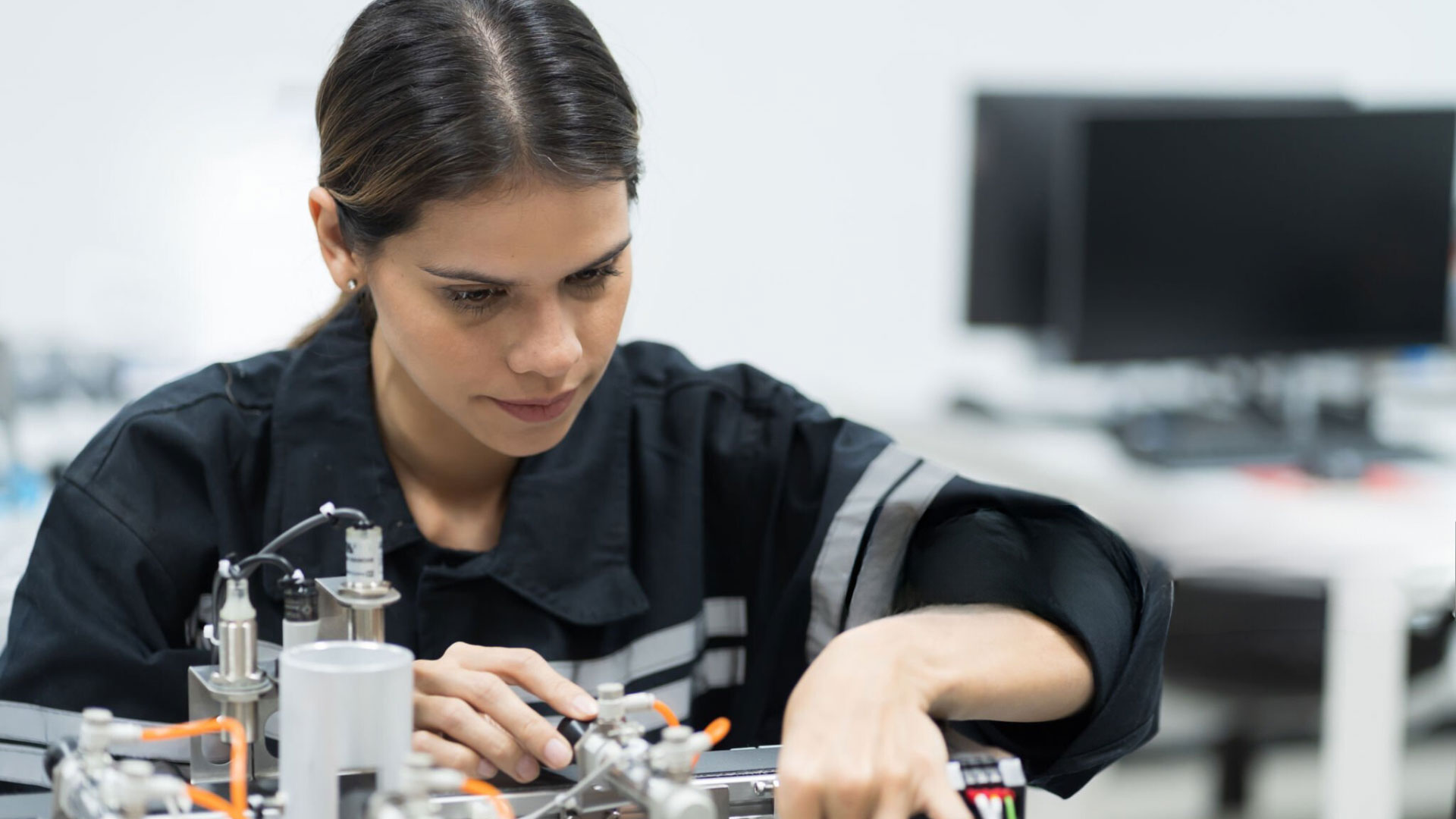 Junge Frau arbeitet an technischer Maschine
