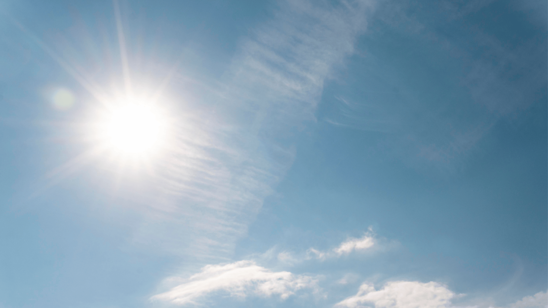 Strahlend heller Sonnenschein am klaren blauen Himmel mit ein paar zarten, dünnen Wolken im Hintergrund.