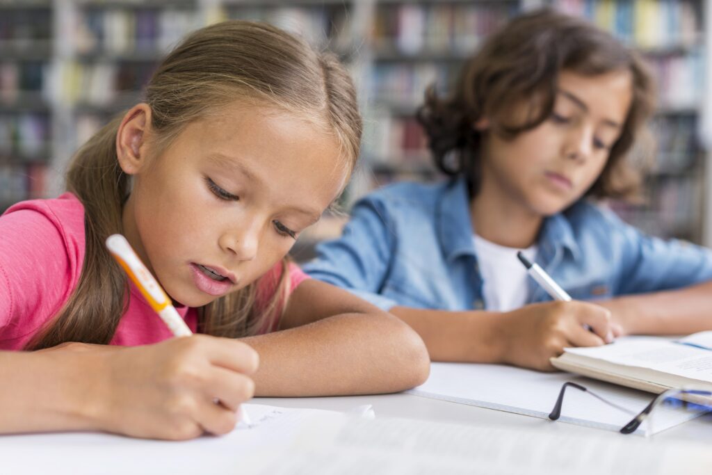 Junge und Mädchen, die am Tisch sitzen und Hausaufgaben machen