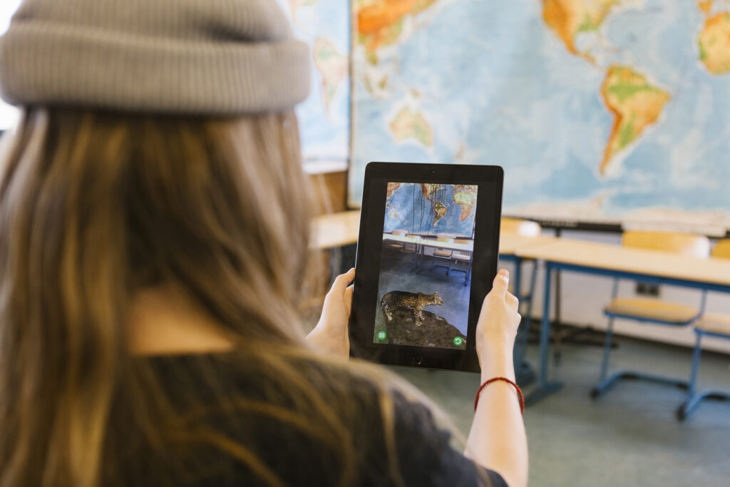 Schülerin von hinten, die einen Leoparden im Tablet betrachtet
